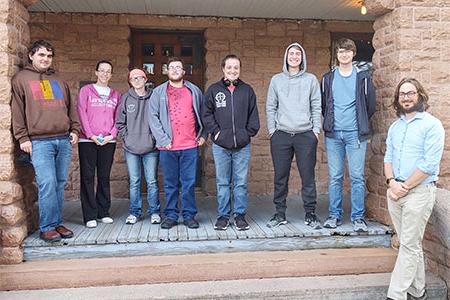 a group poses for a photo in front of the Frank House Museum