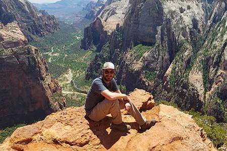 Will Stoutamire posing for a picture sitting in front of mountains